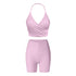 Pink workout set combining wrap-style halter top and high-waisted compression shorts