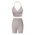 Gray workout set with halter wrap sports bra and high-waisted compression shorts