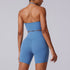 Back view of blue athletic set with halter sports bra and high-waisted biker shorts, showcasing seamless fabric and fit