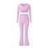 Pink workout set with long sleeve wrap top and flared pants, displaying seamless construction and stretchy material