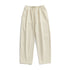 A pair of off-white wide-leg drawstring pants with an elastic waistband and white drawstrings, displayed flat against a white background