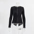 Black pleated top on mannequin displaying round neckline and long sleeves with vertical pleating
