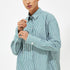 Close-up of green and white striped shirt with buttoned cuff