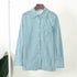 Teal and white striped long-sleeve shirt hanging on display