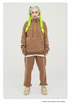 Model with platinum hair and neon yellow braids wearing a tan/camel sweatsuit with oversized hoodie and matching joggers