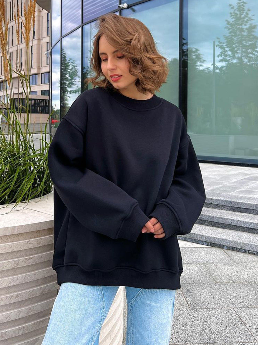 Black oversized crewneck sweatshirt paired with light wash denim, shown in urban setting