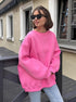 Oversized pink sweatshirt with drop shoulders paired with light jeans and black sunglasses