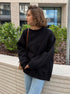 Black oversized sweatshirt with light jeans in casual streetwear style