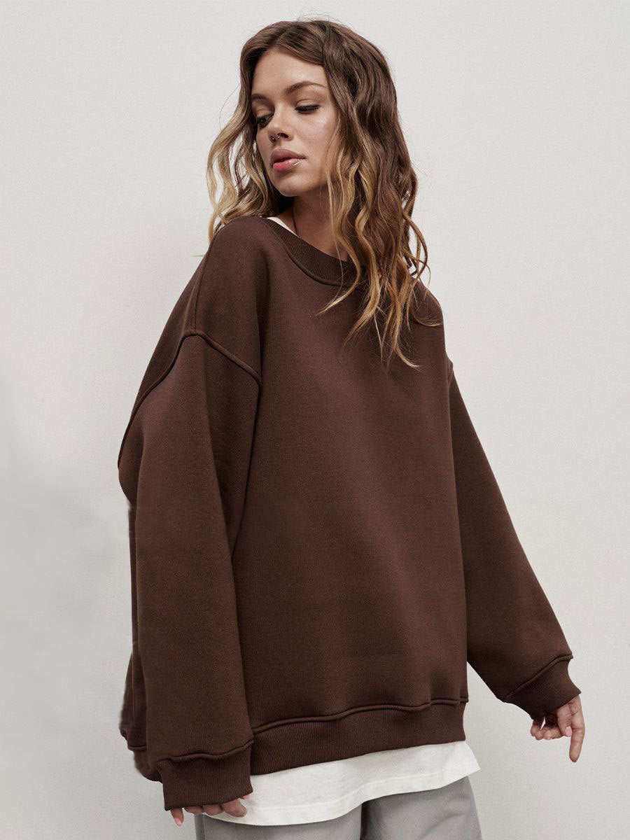Brown oversized sweatshirt layered over white shirt with relaxed silhouette