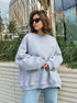 Heather gray oversized sweatshirt worn with sunglasses against urban landscaping with ornamental grasses