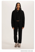 Black Sweatshirt and Joggers Set – Model wears a black cropped hoodie and matching sweatpants with sneakers