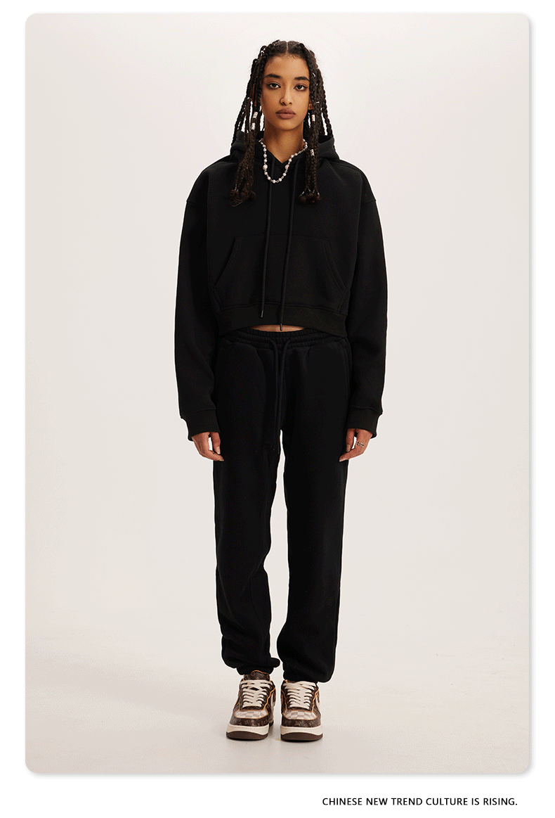 Black Sweatshirt and Joggers Set – Model wears a black cropped hoodie and matching sweatpants with sneakers