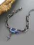 Blue Gemstone Silver Chain Bracelet – A silver chain bracelet featuring a striking blue rectangular gemstone and a matching blue stone on the cross charm