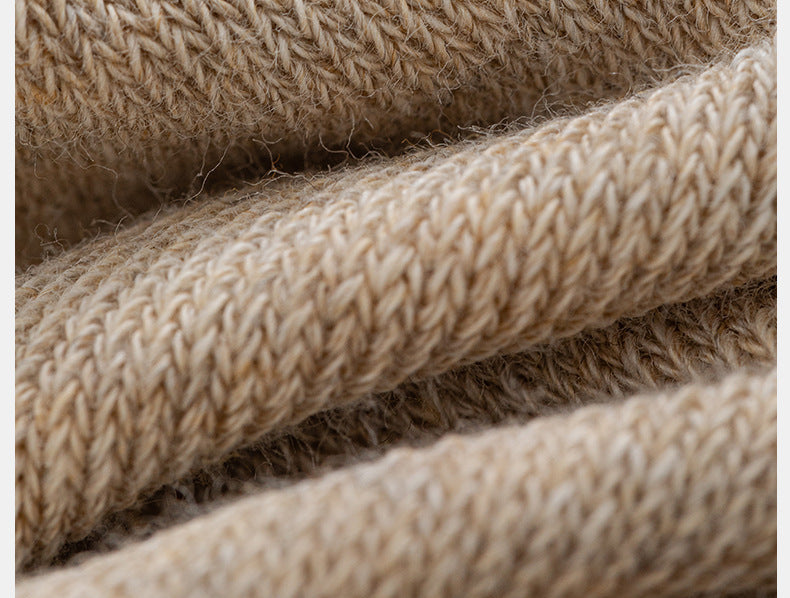 Close-up of beige knit leg warmer showing ribbed pattern texture