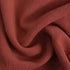 A detailed view of the rust-colored fabric, showing its soft, slightly textured material.