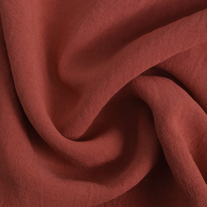 A detailed view of the rust-colored fabric, showing its soft, slightly textured material.