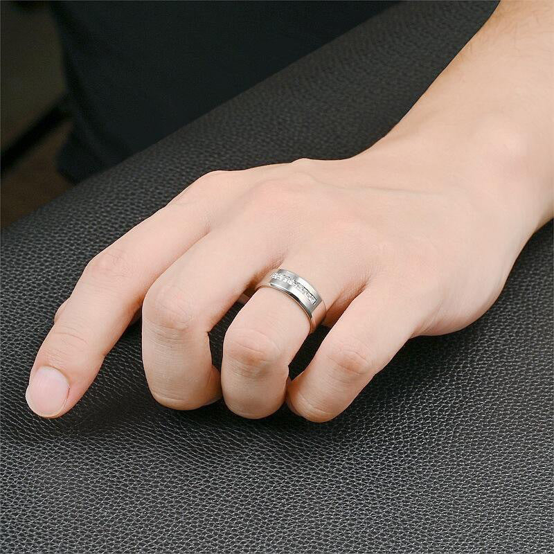 A stylish men's silver ring with a row of cubic zirconia, worn on a hand to showcase its elegant and contemporary design.