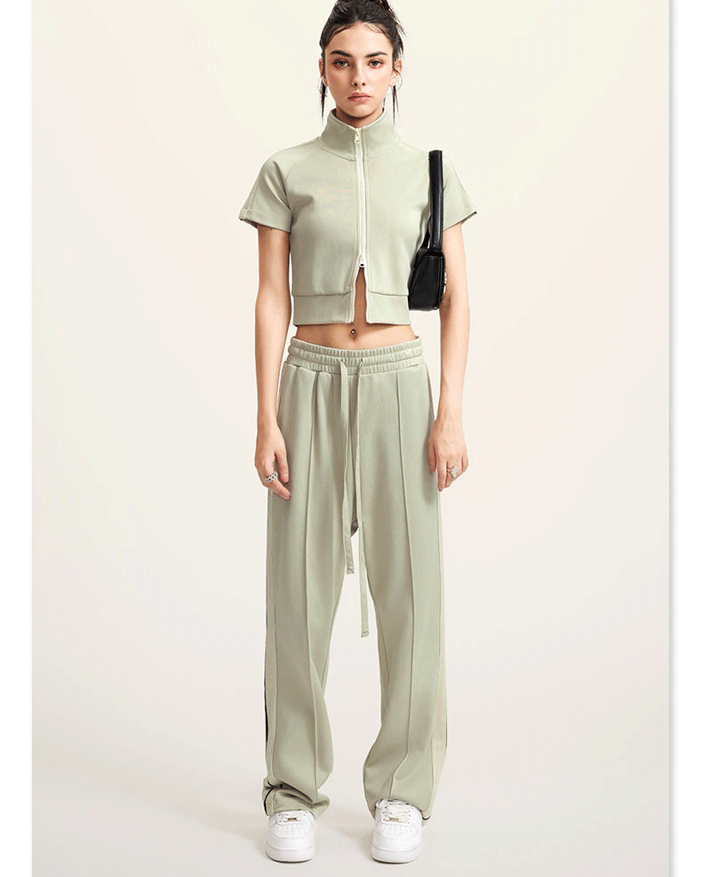 Olive green mock neck crop top with front zip and white sleeve stripes, front view