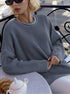 Grey ribbed sweater with silver collar necklace detail, styled with black sunglasses and white teapot on cafe table