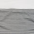 Detailed view of black and white striped fabric laid flat, showing stitching and fabric quality.
