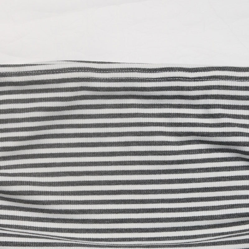 Detailed view of black and white striped fabric laid flat, showing stitching and fabric quality.