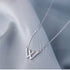 Silver W initial necklace styling photo against gray fabric with 'necklace' text overlay