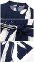 Close-up of the navy jumpsuit showing fabric details, waist tie, and high neckline with a structured collar.