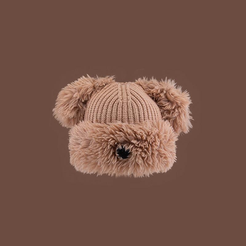 Brown Dog Nose Plush Knit Beanie with plush faux fur trim and pom pom ears against brown backdrop