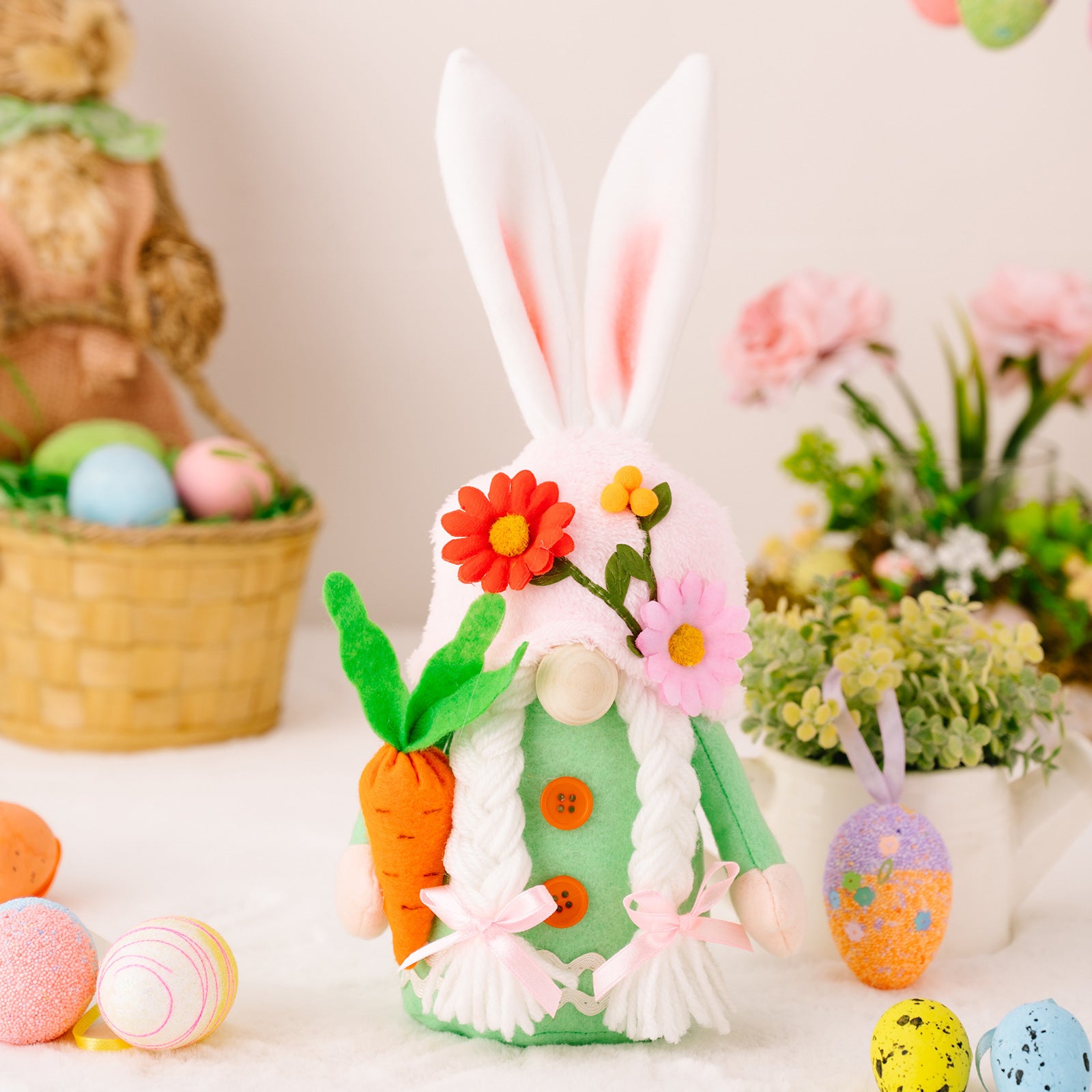 A green-dressed bunny gnome holding a carrot, featuring pink ribbons and floral accents, posed among colorful eggs and festive decorations.