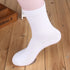 Black cotton crew sock shown on white mannequin leg with wooden backdrop