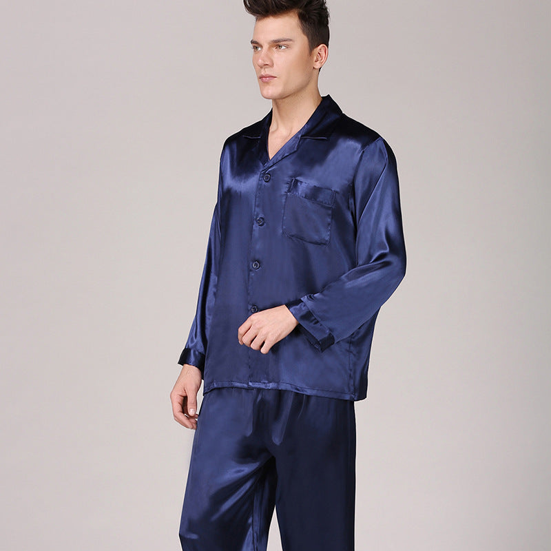 Model in navy blue silk pajama set with classic collar and button-front styling against light gray backdrop