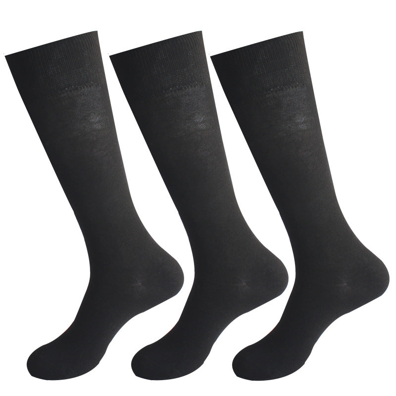 Three pairs of black dress socks with ribbed cuffs displayed against white background