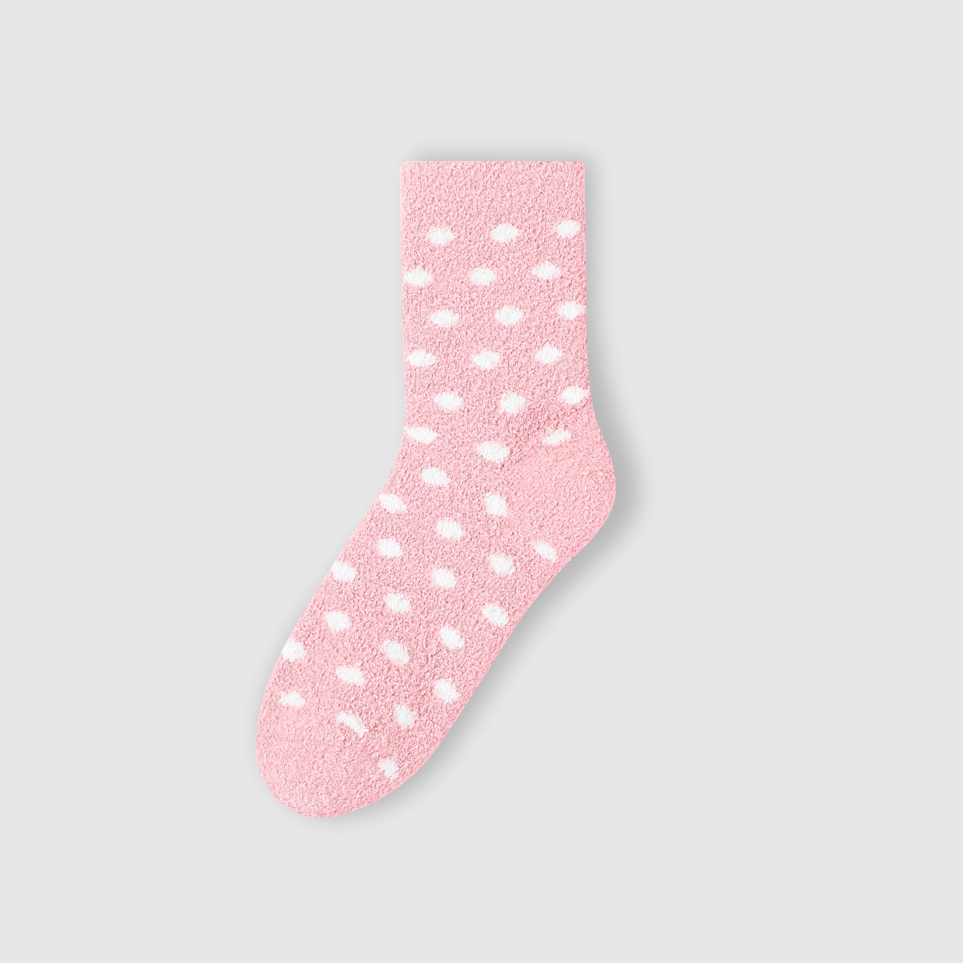 Pink fuzzy sock with white polka dot pattern against white background