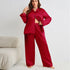 Model in red satin pajama set with black buttons, showing midriff, accessorized with crystal necklace