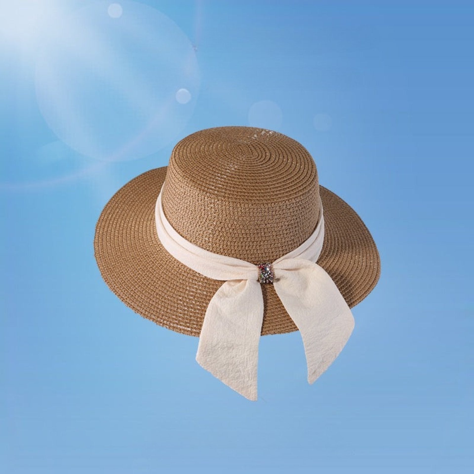 Chic brown wide brim straw hat for women, featuring a cream bow with a crystal accent. A perfect blend of elegance and sun protection for summer days.