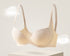 Seamless light nude-colored push-up bra with a smooth finish, molded cups, and subtle contour lines for shaping.