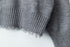 Ribbed hem with intentionally distressed edges, showing texture contrast between main body and trim.