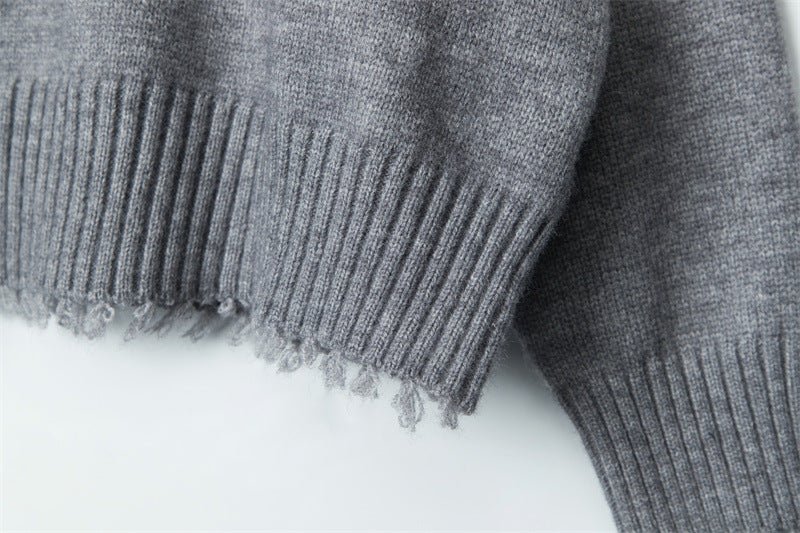 Ribbed hem with intentionally distressed edges, showing texture contrast between main body and trim.
