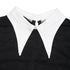 A close-up of the white pointed collar on a black lace dress, highlighting the fabric contrast and button closure.