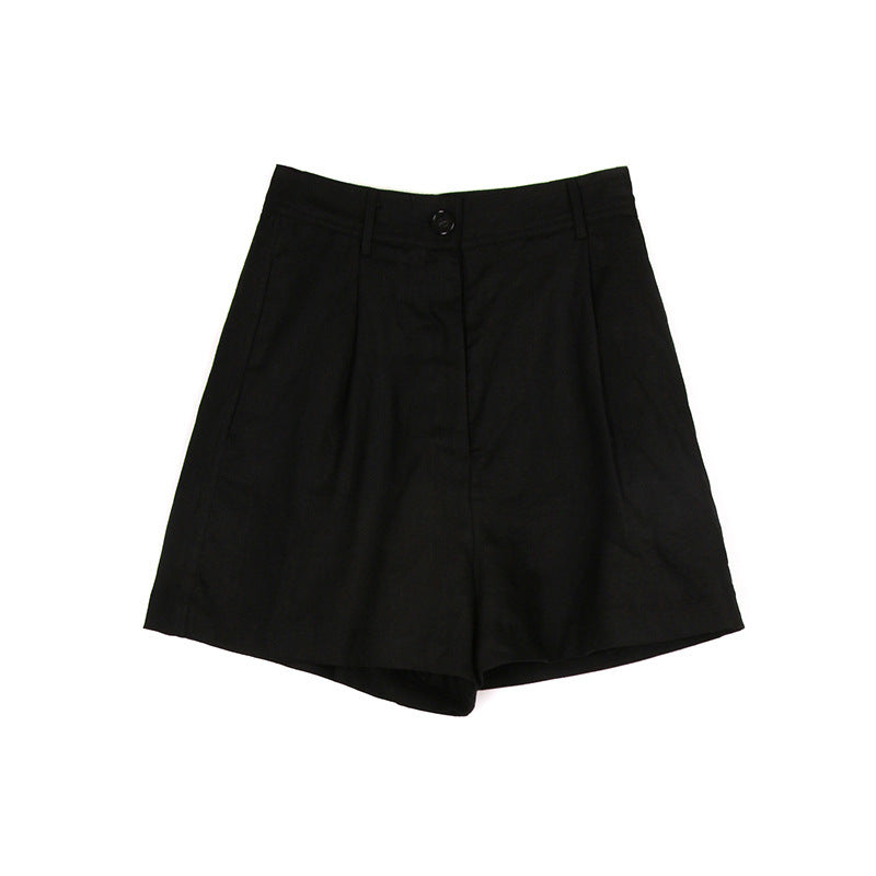 Black pleated linen shorts photographed flat lay style showing tailored cut and button detail on white background