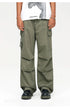 A model wearing olive green wide-leg cargo pants with multiple pockets, paired with white graphic tee and black platform shoes
