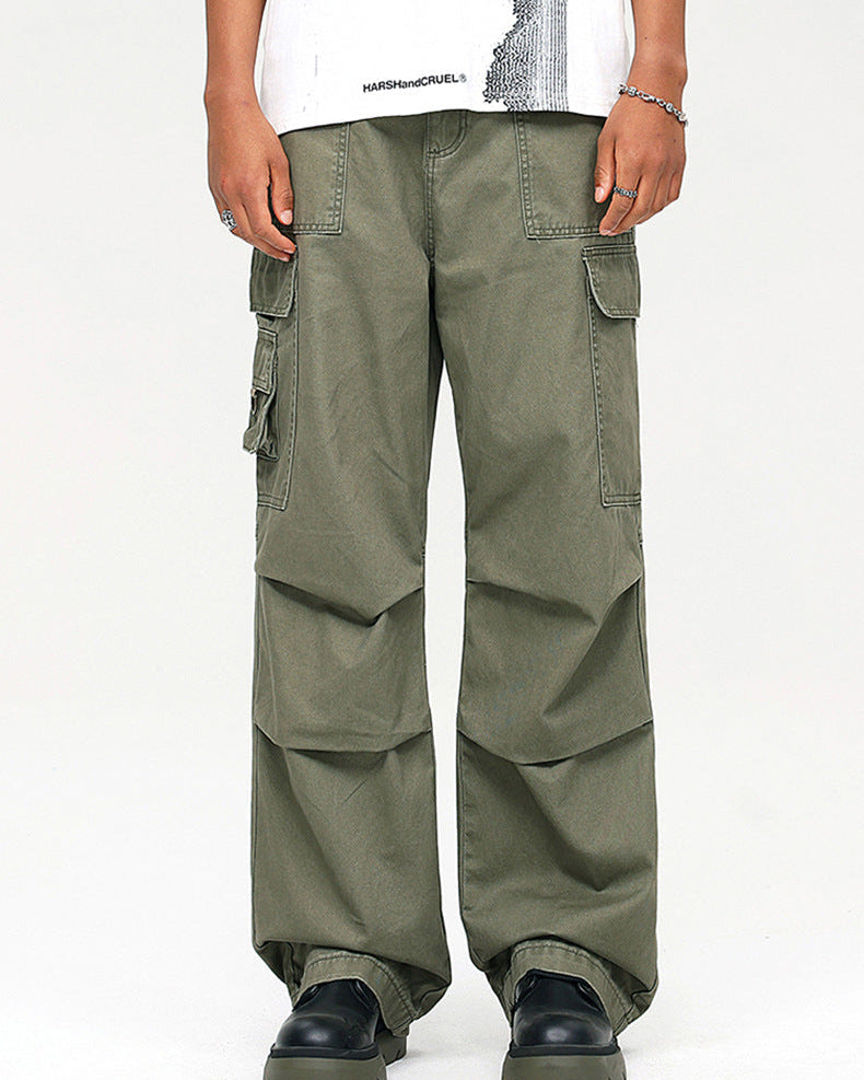 A model wearing olive green wide-leg cargo pants with multiple pockets, paired with white graphic tee and black platform shoes