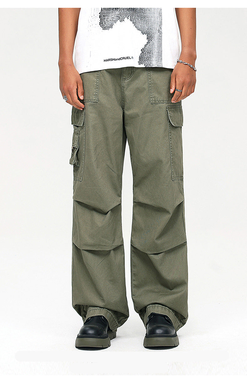 A model wearing olive green wide-leg cargo pants with multiple pockets, paired with white graphic tee and black platform shoes