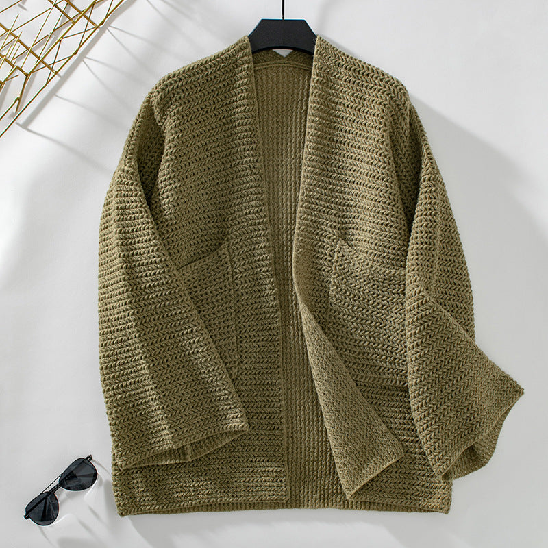 Olive green cardigan on hanger against white background, displaying chunky knit texture and relaxed fit