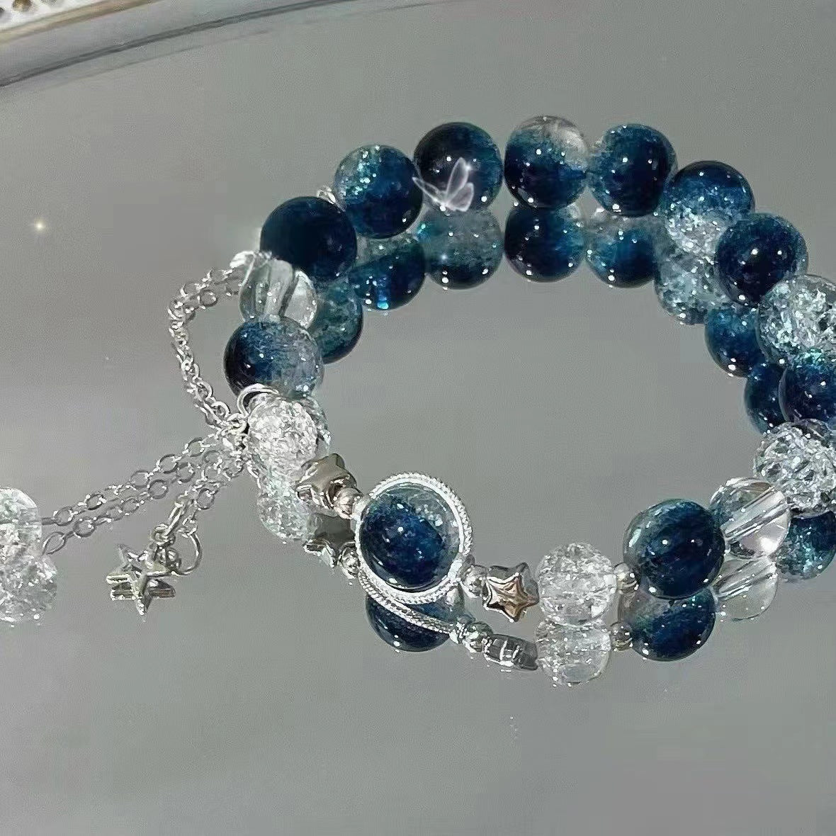 Deep blue and clear crystal beaded bracelet with silver star charms and center medallion