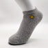 Gray cotton ankle sock with yellow smiley face logo and ribbed design