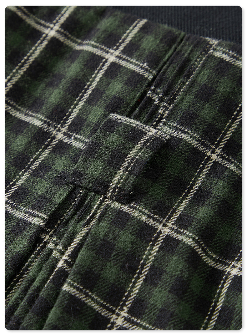 Close-up of green plaid fabric texture with white grid pattern against dark background