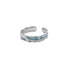 A silver open-ended ring featuring a blue enamel wave pattern with a textured, rugged design