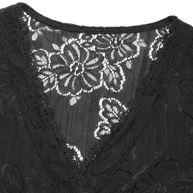Close-up of black lace blouse's V-neckline, highlighting delicate floral lace and scalloped edges.