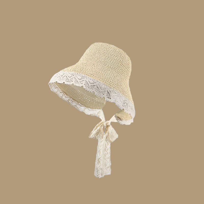 Beige woven straw hat with a lace-trimmed brim and a tie, displayed on a solid brown background.